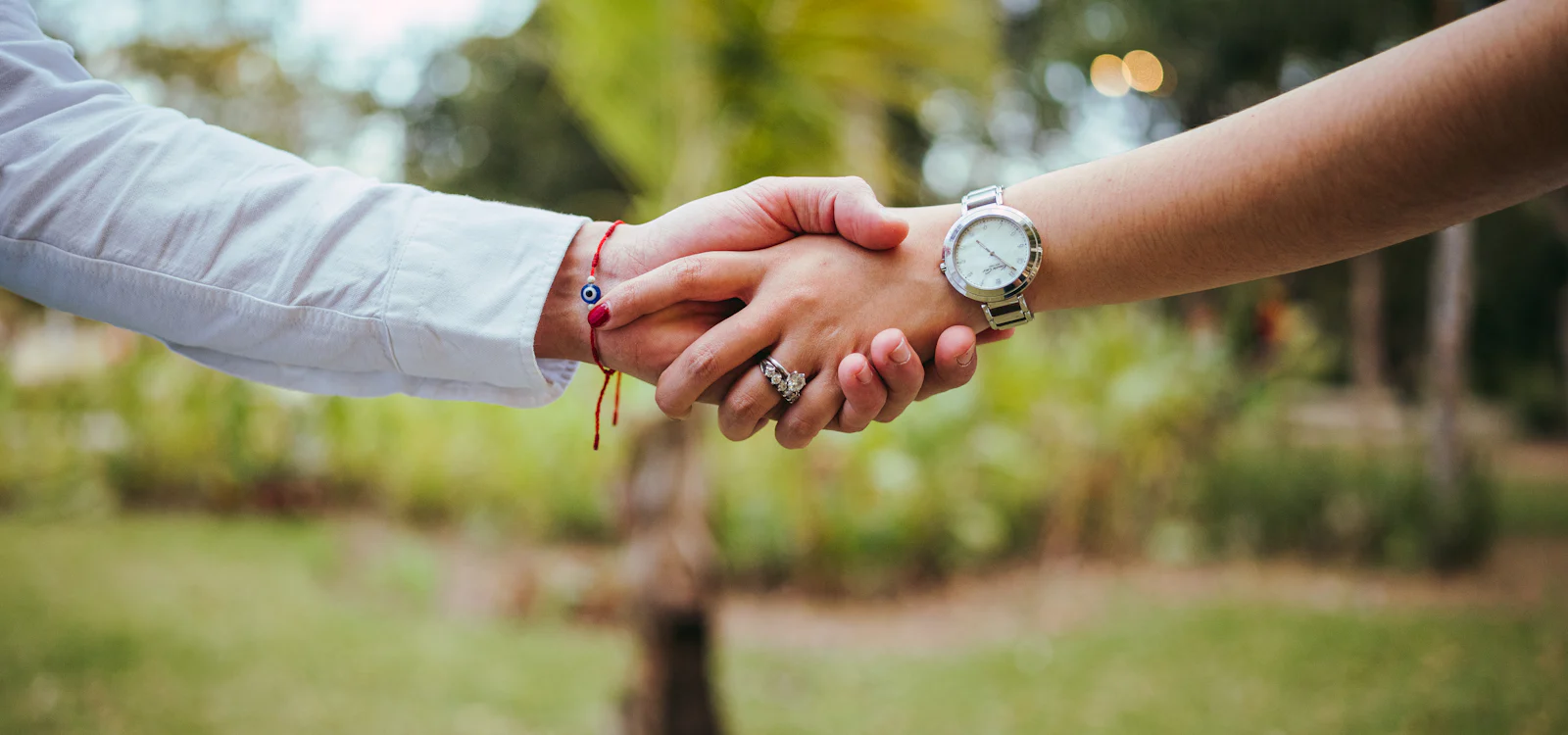 Two people shaking hands outdoors, sealing an agreement